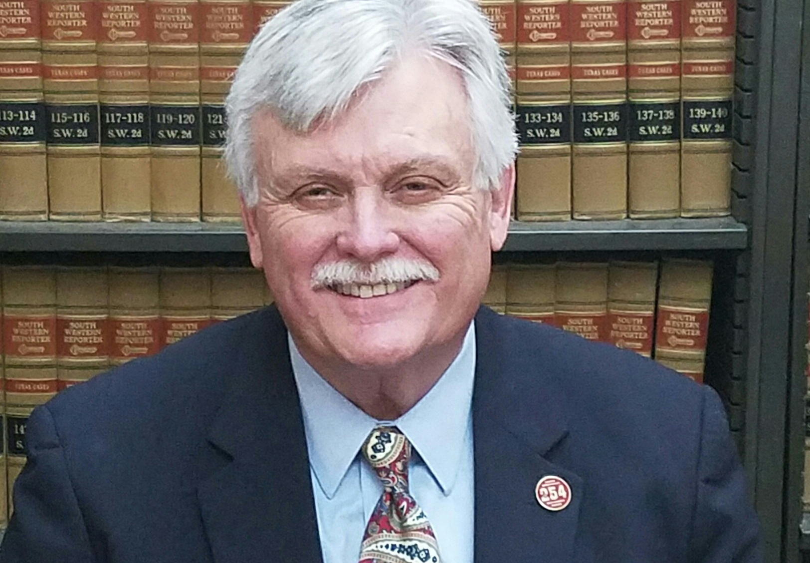 Robert L. Hurley seated in front of law books